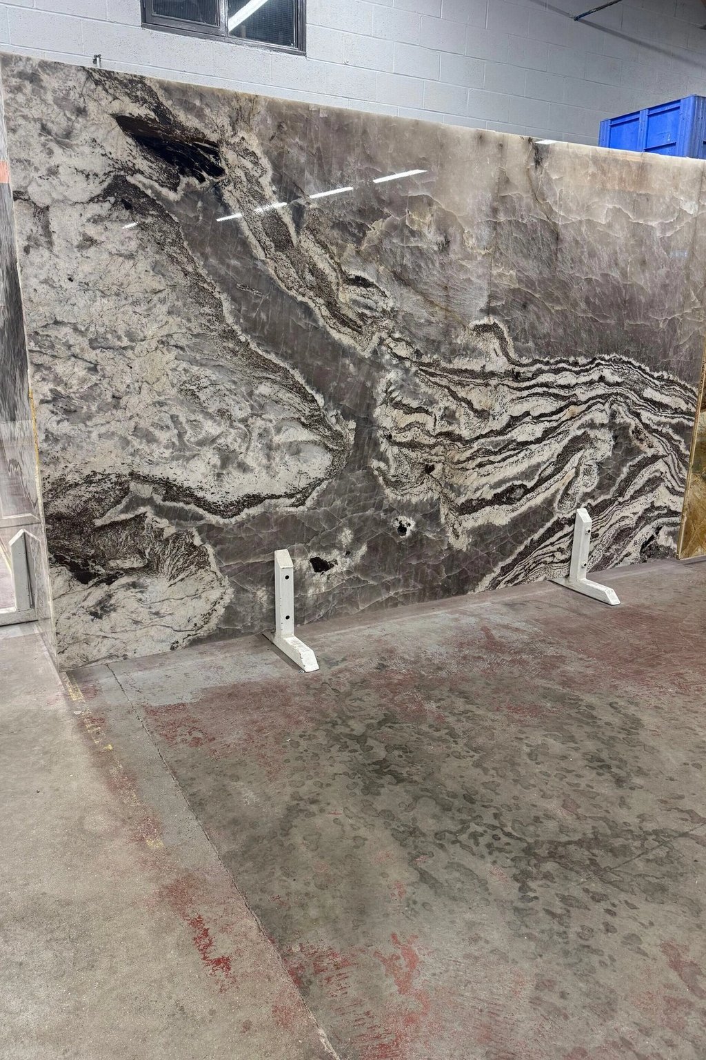 Large grey granite slab with flowing natural pattern in the RH Stone Surfaces showroom