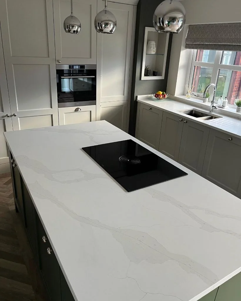 White quartz kitchen island with inset hob & matching worktops.